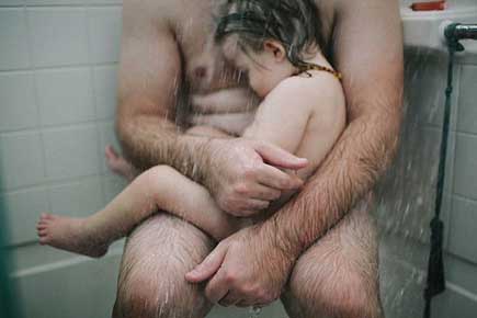 Pic of dad cradling sick son in shower goes viral despite Facebook's efforts
