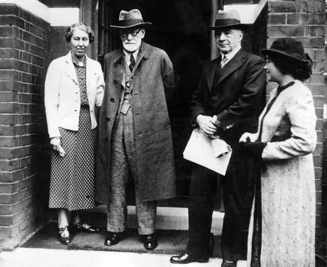 Sigmund Freud (1856-1939, C), Austrian psychiatrist and founder of psychoanalysis and his daughter Anna (1895-1982, L) pose for the photographer in front of their London house in the 1930