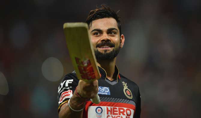 Royal Challengers Bangalore captain and batsman Virat Kohli gestures to the cheering crowd as he walks back to the pavilion after being dismissed for 113 runs during the 2016 Indian Premier League (IPL) Twenty20 cricket match between Royal Challengers Bangalore and Kings XI Punjab, at the M. Chinnaswamy Stadium in Bangalore on Wednesday.