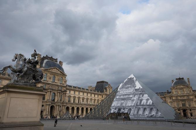 Louvre Pyramid covered with a giant photograph of the museum by French artist and photographer JR in Paris, France