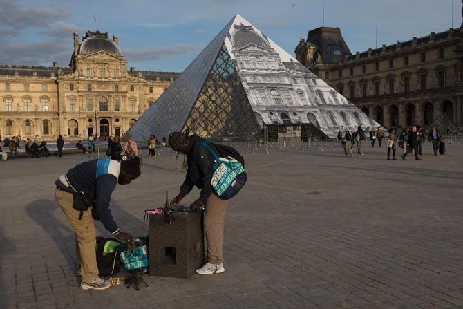 Louvre Pyramid covered with a giant photograph of the museum by French artist and photographer JR in Paris, France