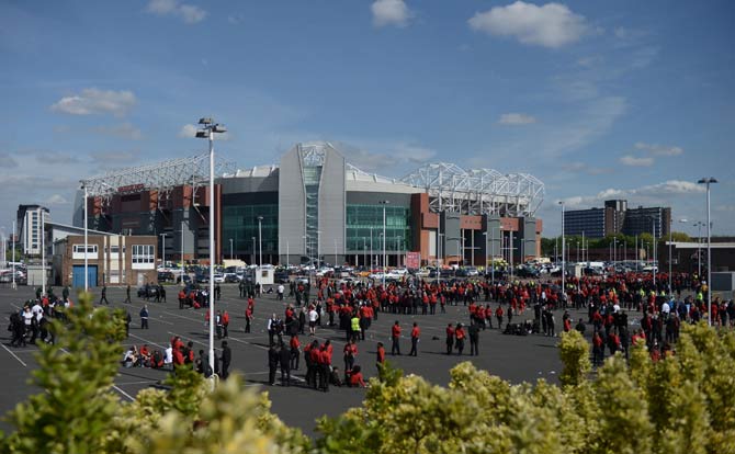 Old Trafford stadium workers stand in a car park outside the stadium in Manchester, north west England, on May 15, 2016