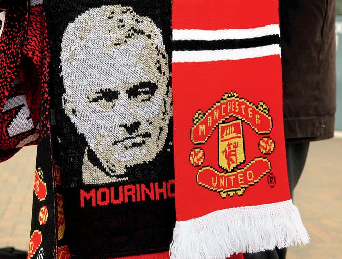 Scarves with new manager Jose Mourinho’s image are displayed for sale outside Man United’s Old Trafford Stadium yesterday. Pic/AFP