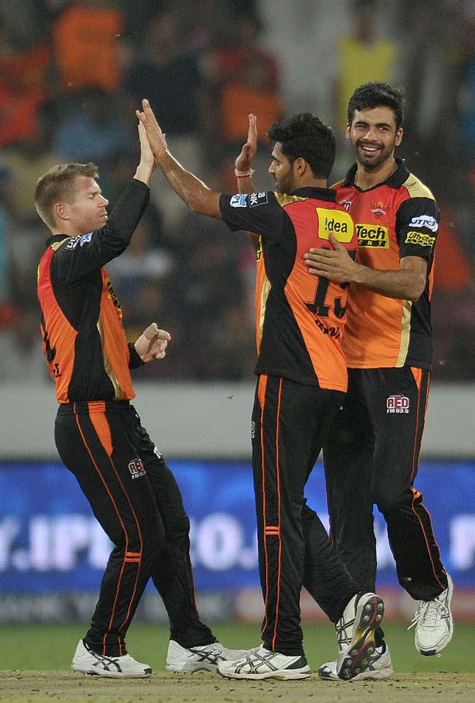 Bhuvneshwar Kumar (2R) celebrates with teammates including captain David Warner(L) after taking the wicket