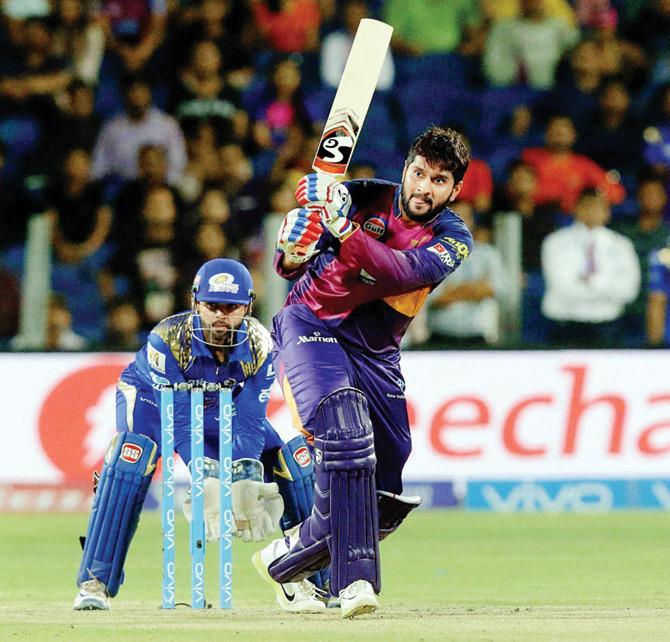 Rising Pune Supergiants’ Saurabh Tiwary smashes one on the leg side as Mumbai Indians ’keeper Parthiv Patel looks on during their IPL match at Pune’s  MCA Stadium on Sunday. Pic/PTI
