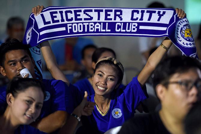 A female fan celebrates Leicester winning the title