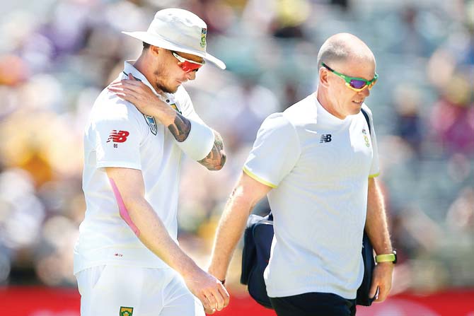 South Africa’s Dale Steyn (left) walks off the field with the team physio after injuring his shoulder in Perth yesterday. Pic/Getty Images