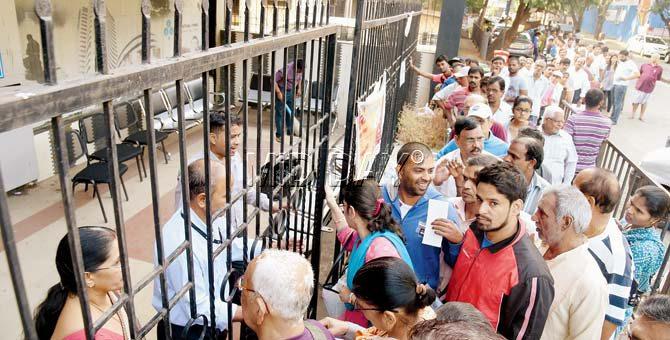 People waiting outside State Bank of India branch at Vazira, Borivali (W). Pic/Nimesh Dave