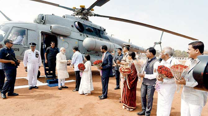 Belagavi: Prime Minister Narendra Modi being welcomed on his arrival at KSRPTC Helipad in Belagavi, Karnataka. His demonetisation move which caught everybody unawares, has set the markets hopping adding to concerns in an uncertain global climate. Pic/PTI