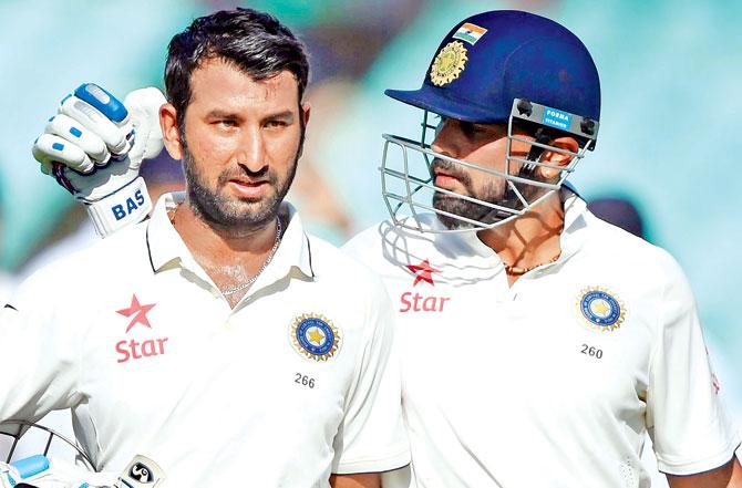 Murali Vijay (right) consoles teammate Cheteshwar Pujara after he was given out on the third day of the first Test against England in Rajkot on November 11, 2016. Pic/AFP