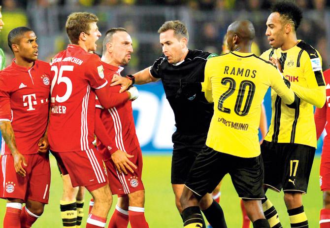 Referee Tobias Stieler (centre) breaks up a scuffle between Dortmund