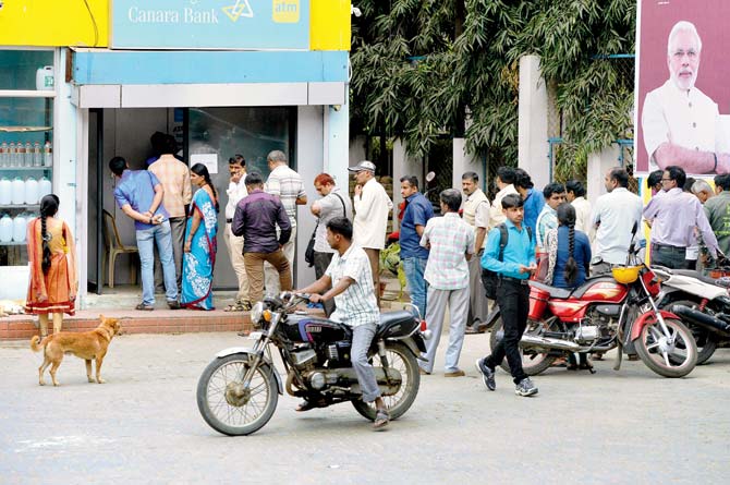 Two weeks after the demonetisaton drive began, citizens continue to spend hours waiting in queues to withdraw new currency notes from ATMs and banks. Pic/AFP