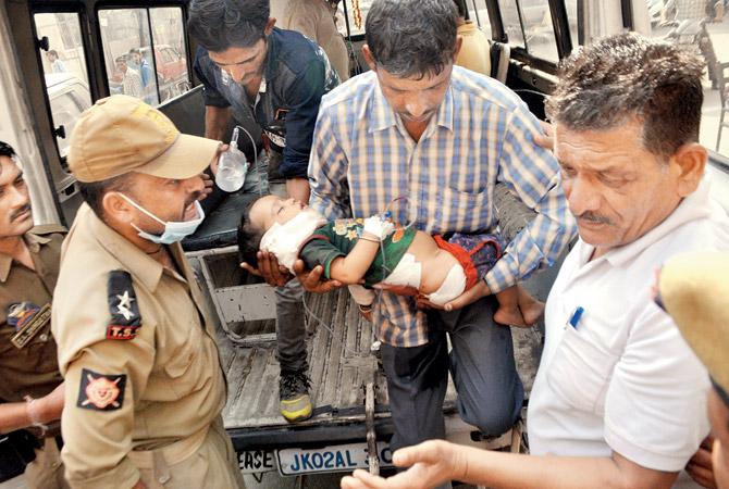 Pari (2), who was injured in the cross-border shelling, is taken to a hospital in Jammu. Pic/AFP