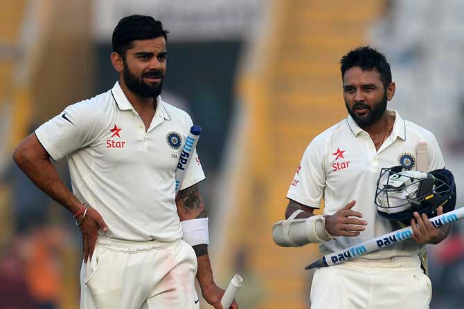 India skipper Virat Kohli and Parthiv Patel walk off the field after winning the third Test match against England in Mohali. Pic/ AFP