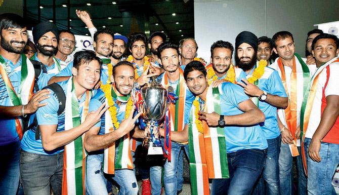 Indian hockey players pose with the Asian Champions Trophy on arrival at the New Delhi airport on Monday. Pic/PTI