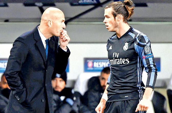 Real Madrid coach Zinedine Zidane (left) interacts with Gareth Bale during their Champions League tie vs Legia on Wednesday. Pic/AFP