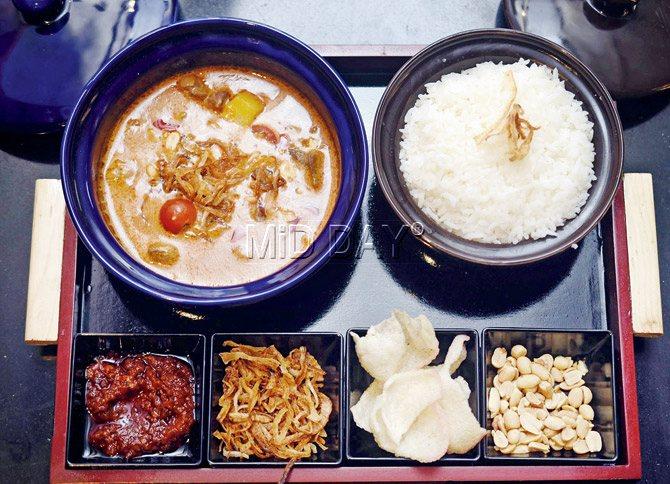 Slow Cooked Lamb Massaman Curry served with sticky rice and a variety of condiments