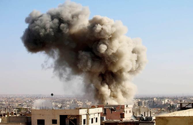 Smoke billows after an air strike by Syrian forces in Daraa. Pic/AFP