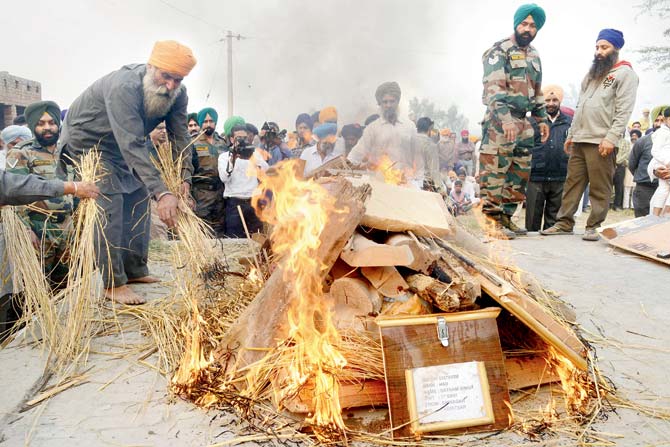 Ajit Singh (L), brother of soldier Satnam Singh, lights the martyr’s pyre in Amritsar. Satnam died in Kupwara on November 9. Pic/AFP