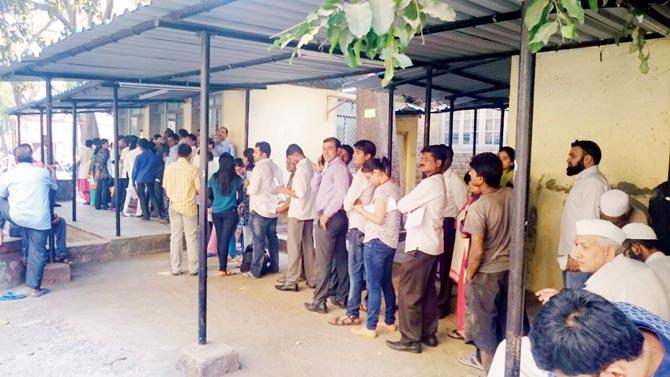 People queue up outside the counters to exchange defunct currency notes