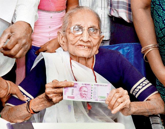 The PM’s mother Heeraben Modi shows the new note she got after exchanging old Rs 500 notes