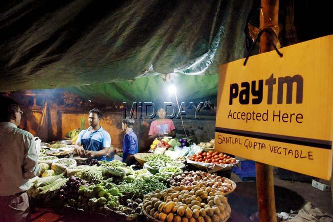 Manoj Gupta of Santlal Gupta vegetable stall accepts e-cash at his Kalanagar stall. Pic/Pradeep Dhivar