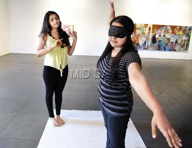 Yoga practitioner Priyanka Nair guides the reporter to practise Trikonasana at a trial session of blindfolded Ashtanga Yoga at The Viewing Room, an art gallery in Colaba. Pics/Pradeep Dhivar