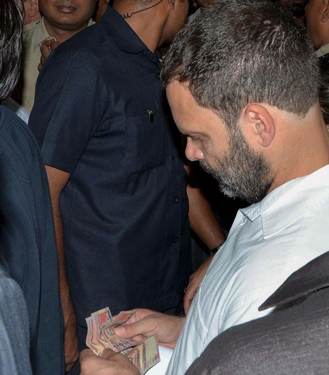Rahul visits bank to exchange old notes, hits out at PM