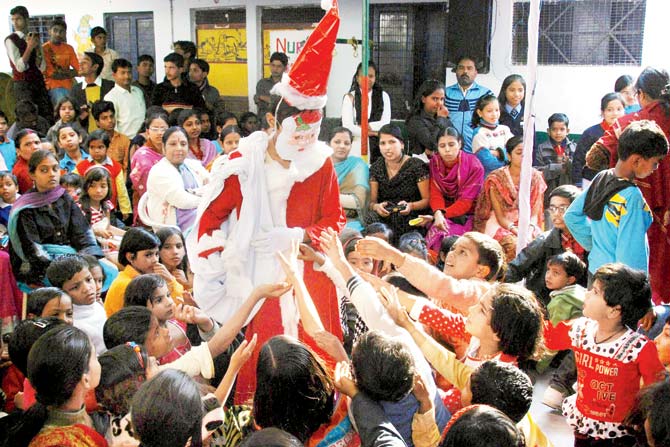 A child dressed as Santa Claus, distributes sweets during a school function. Pic/AFP