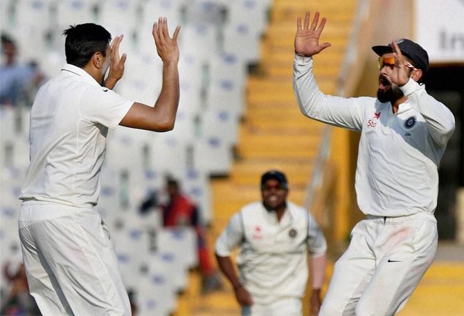  Indian captain Virat Kohli celebrates the wicket of Moeen Ali with Ravichandran Ashwin on the third day of the third Test match between India and England, in Mohali on Monday.