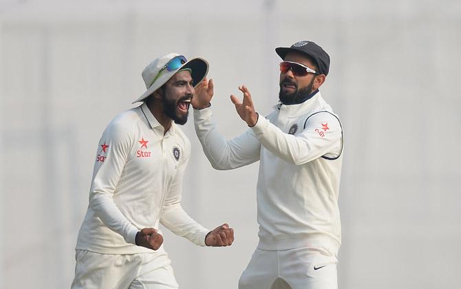  Ravindra Jadeja (L) and captain Virat Kohli celebrate the dismissal of England batsman Jos Buttler