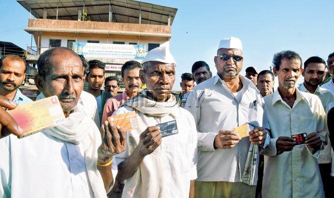 A group of residents in Dhasai show off their debit cards. PIC/NIMESH DAVE