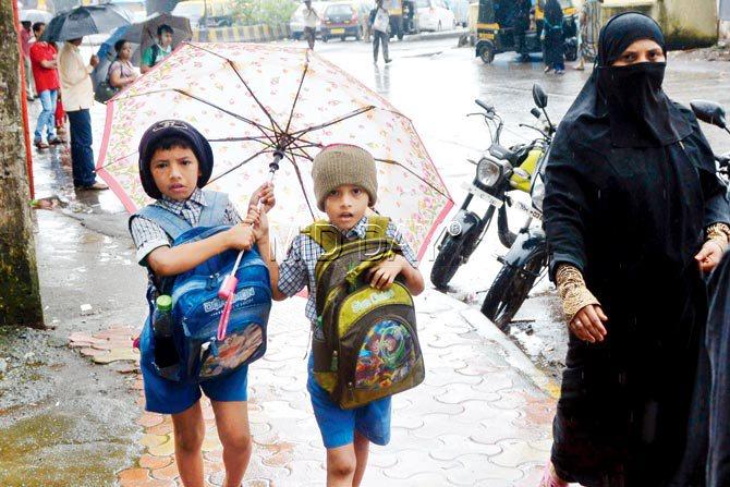 Schoolchildren brave the rain and fog to reach school. Pic/Sayyed Sameer Abedi