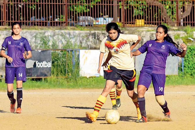 Cathedral & John Connon’s Shamika Bhandarkar (right) is tackled by St Xavier’s Riya Coutinho during the DSO girls’ U-19 match at Azad Maidan yesterday. pic/ATUL KAMBLE