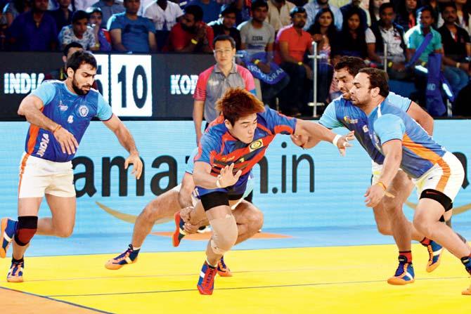 Indian players try to tackle a Korean opponent (centre) during the Kabaddi World Cup in Ahmedabad yesterday. India lost 32-34
