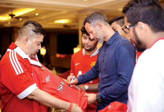 Sunil Thakur (left) gets a Manchester United jersey autographed by RyanâÂu00c2u0080Âu00c2u0088Giggs