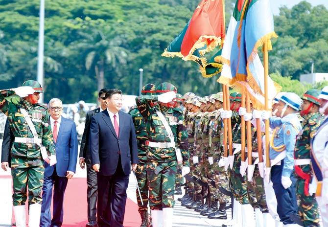 Chinese President Xi Jinping reviews an guard of honour after arriving in Dhaka. Pic/AFP