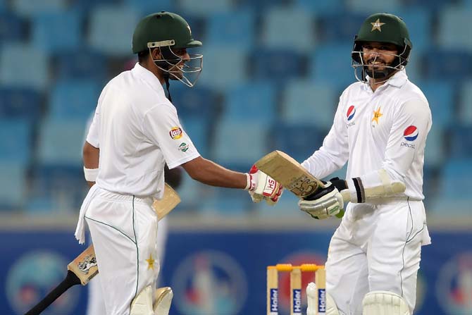 Pakistani batsman Azhar Ali (R) shakes hands with teammate Babar Azam as he celebrates after scoring double century (200 runs) against West Indies. Pic/ AFP
