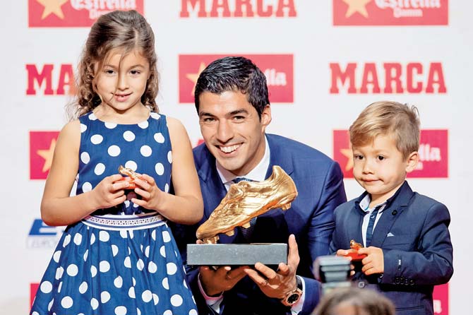 Luis Suarez poses with his daughter Delfina and son Benjamin with the Golden Boot as the best goal scorer in all European Leagues last season in Barcelona, Spain on Thursday. PIC/Getty Images 