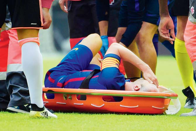 Barcelona’s Andres Iniesta is stretchered off after suffering an injury during the La Liga tie against Valencia on Saturday. pic/AFP