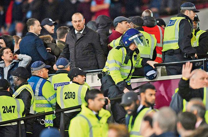 Riot police try to take control of the fans during the match between West Ham United and Chelsea at The London Stadium in London on Wednesday. Pic/Getty Images