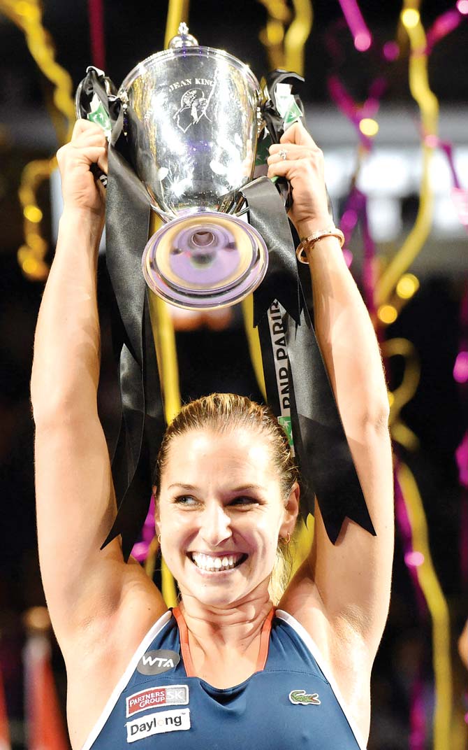 Dominika Cibulkova lifts the trophy after beating Angelique Kerber at the WTA Finals in Singapore yesterday. Pic/AFP