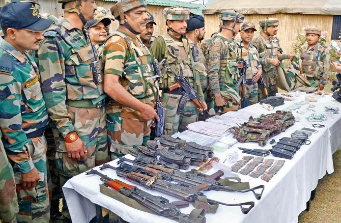 Army officers display the recoveries made from the terrorists. Pic/PTI
