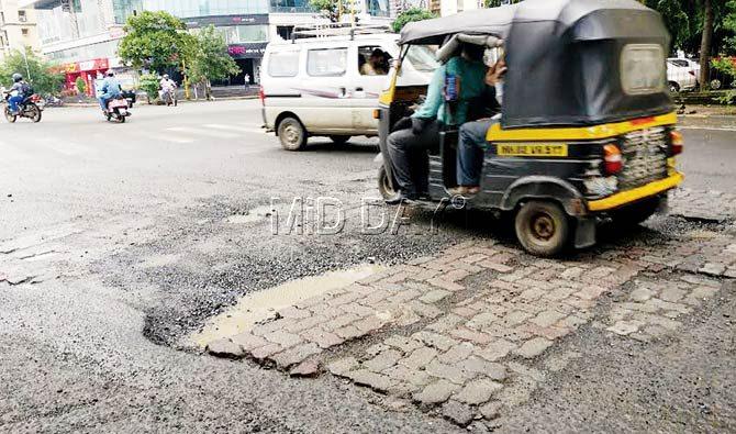 An autorickshaw driver deftly avoids a pothole on New Link Road in Borivli West. Traffic snarls and frequent rallies add to the burden on roads, and worsen their condition. Pic/Nimesh Dave