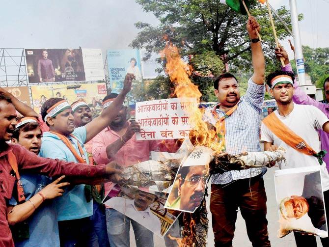 BJP activists in Patna protest against Arvind Kejriwal and Om Puri over their recent remarks on the surgical strikes. Pic/PTI