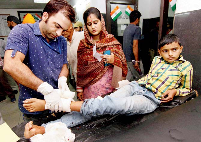 A boy hurt in the firing is treated in RSâu00c2u0080u00c2u0088Pura. Pic/PTI