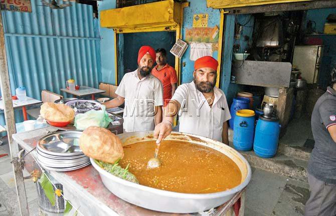 Gurjit Singh (right), owner of Chawla’s, gives the chhole a stir. Pics/Suresh Karkera