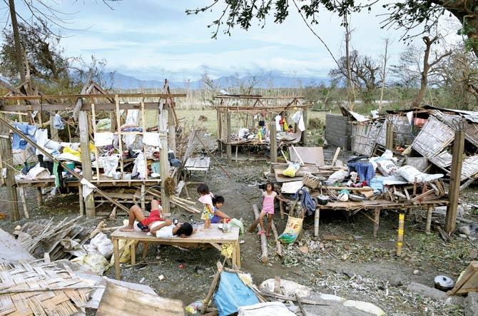 Children play amid their destroyed houses after typhoon Haima hit their homes near San Pablo town on Thursday. PIC/AFP
