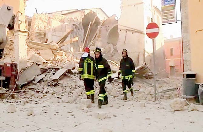 Firefighters outside  the destroyed basilica of Norcia. Pic/AFP