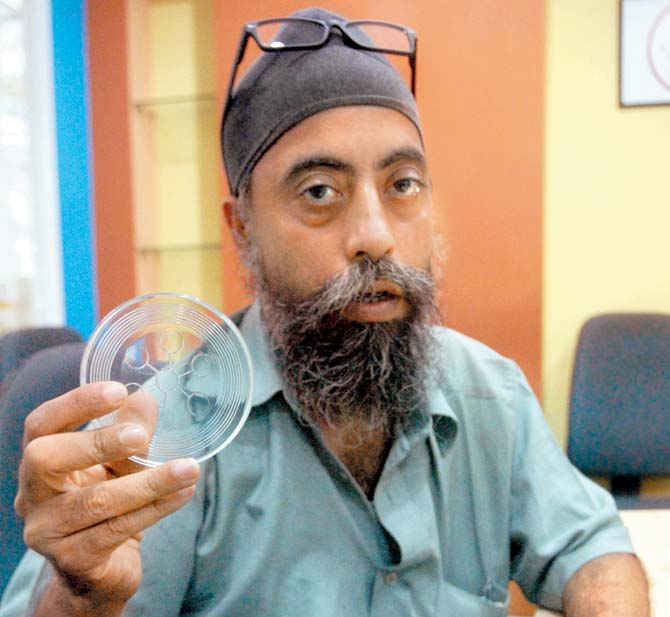 Gurupreet Singh Anand holds up the bio-disc that was sold by QNet
